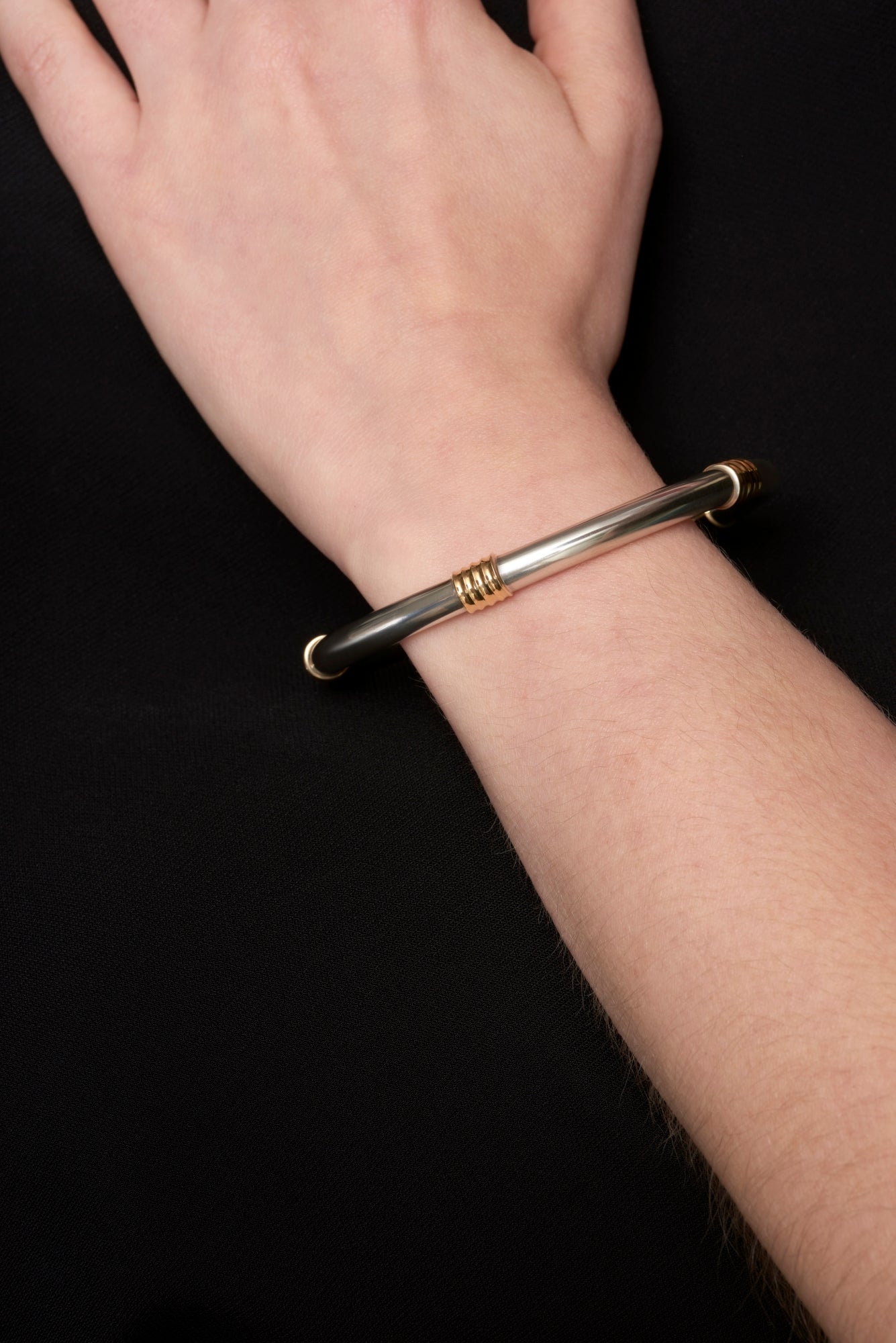 A Cousins ONE IN FIVE. A solid silver & 18 carat yellow gold bangle