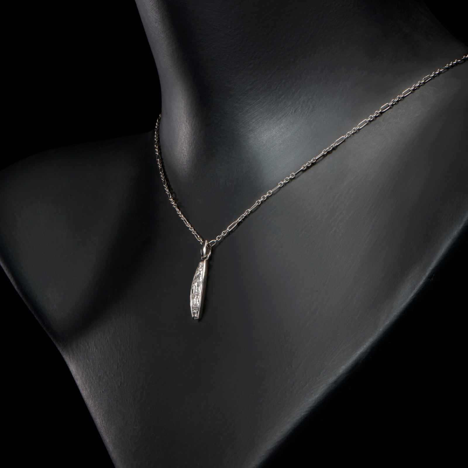 A diamond five stone tonneau baton pendant