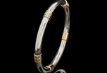 A Cousins ONE IN FIVE. A solid silver & 18 carat yellow gold bangle
