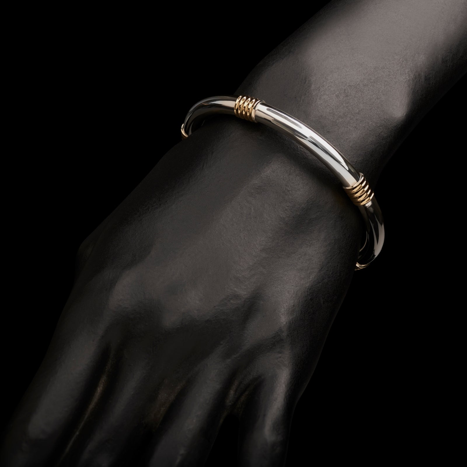 A Cousins ONE IN FIVE. A solid silver & 18 carat yellow gold bangle