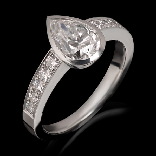 A single stone Pendalogue drop diamond ring with diamond set shoulders