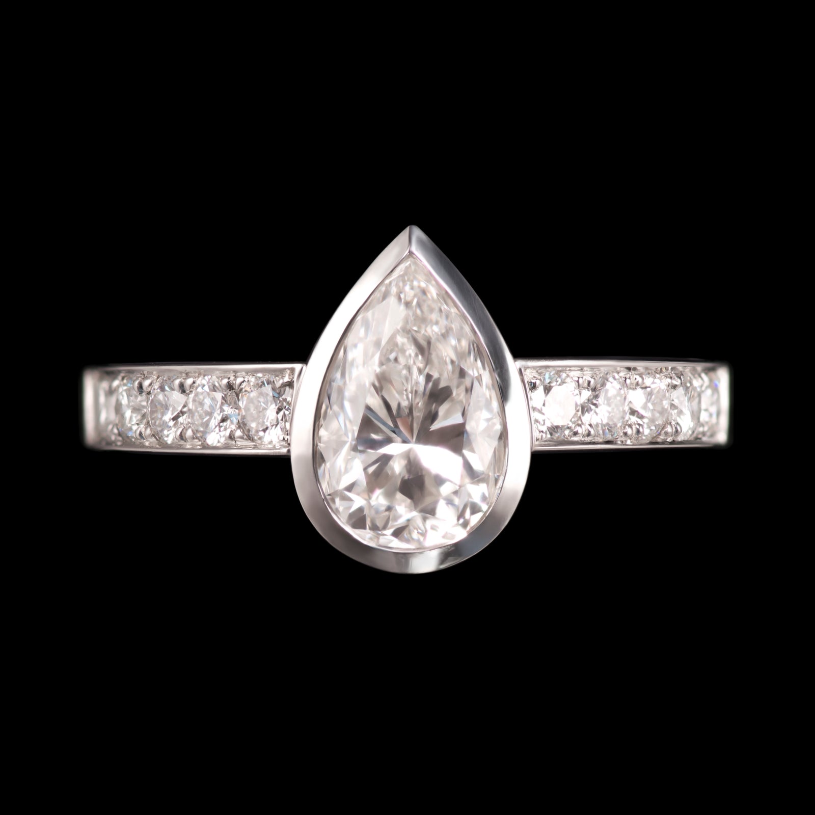 A single stone Pendalogue drop diamond ring with diamond set shoulders