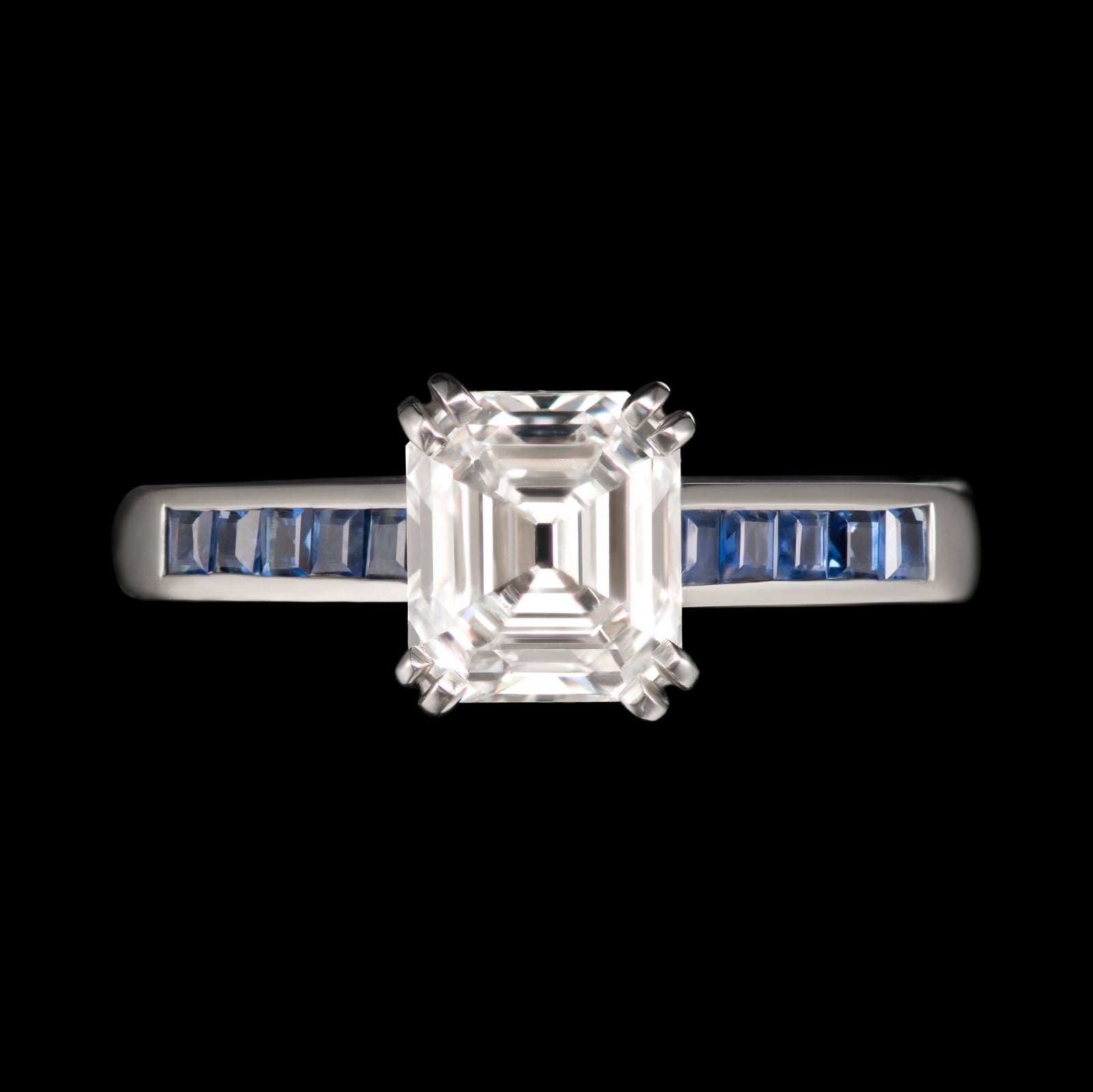 An exceptional emerald cut diamond single stone ring with sapphire shoulders