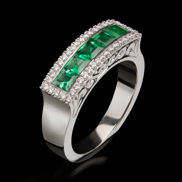 An Emerald & Diamond half hoop ring with Diamond surround.