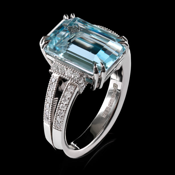 An Aquamarine single stone Ring with Diamond set shoulders.