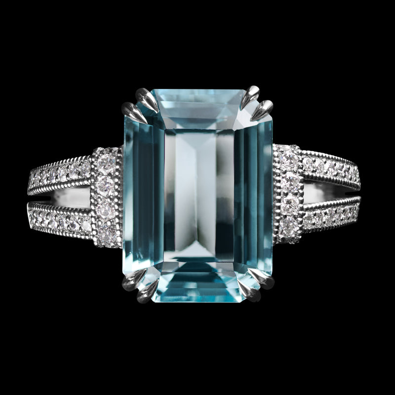 An Aquamarine single stone Ring with Diamond set shoulders.