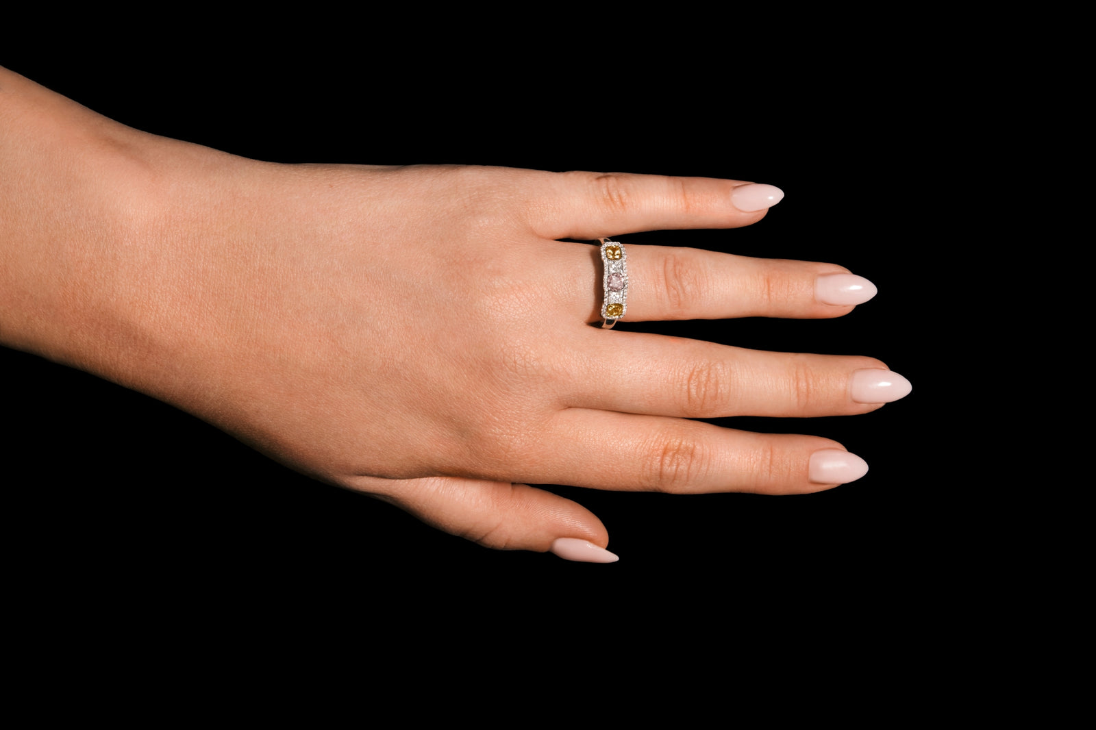 An all diamond half hoop ring with three fancy natural colour diamonds.