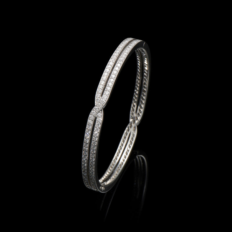 A diamond cross over bangle in platinum