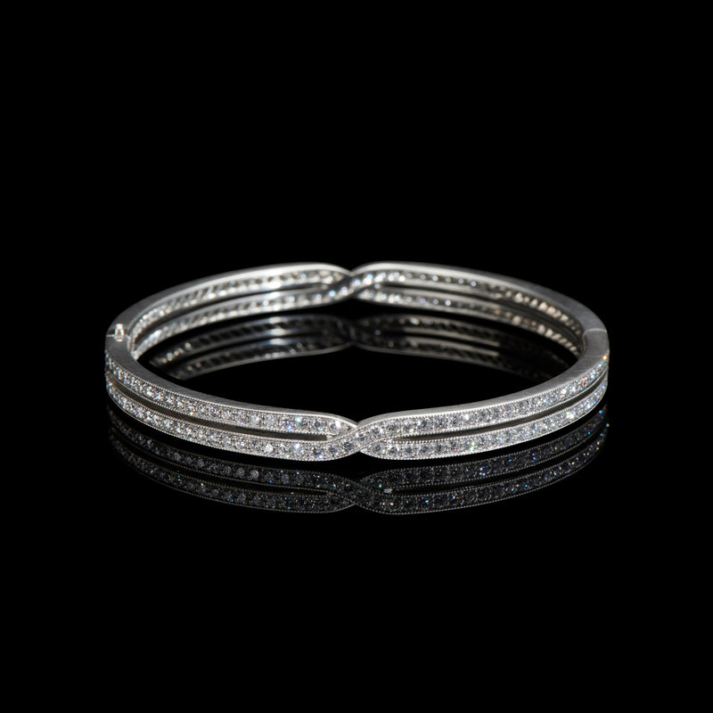 A diamond cross over bangle in platinum