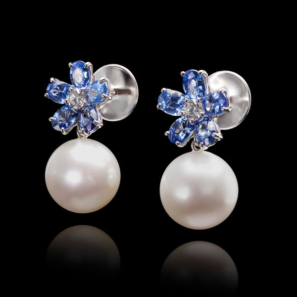 A pair of pearl drop earrings with sapphire & diamond petal cluster tops