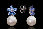 A pair of pearl drop earrings with sapphire & diamond petal cluster tops