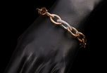 An 18 carat rose gold navette link bracelet with diamond set link