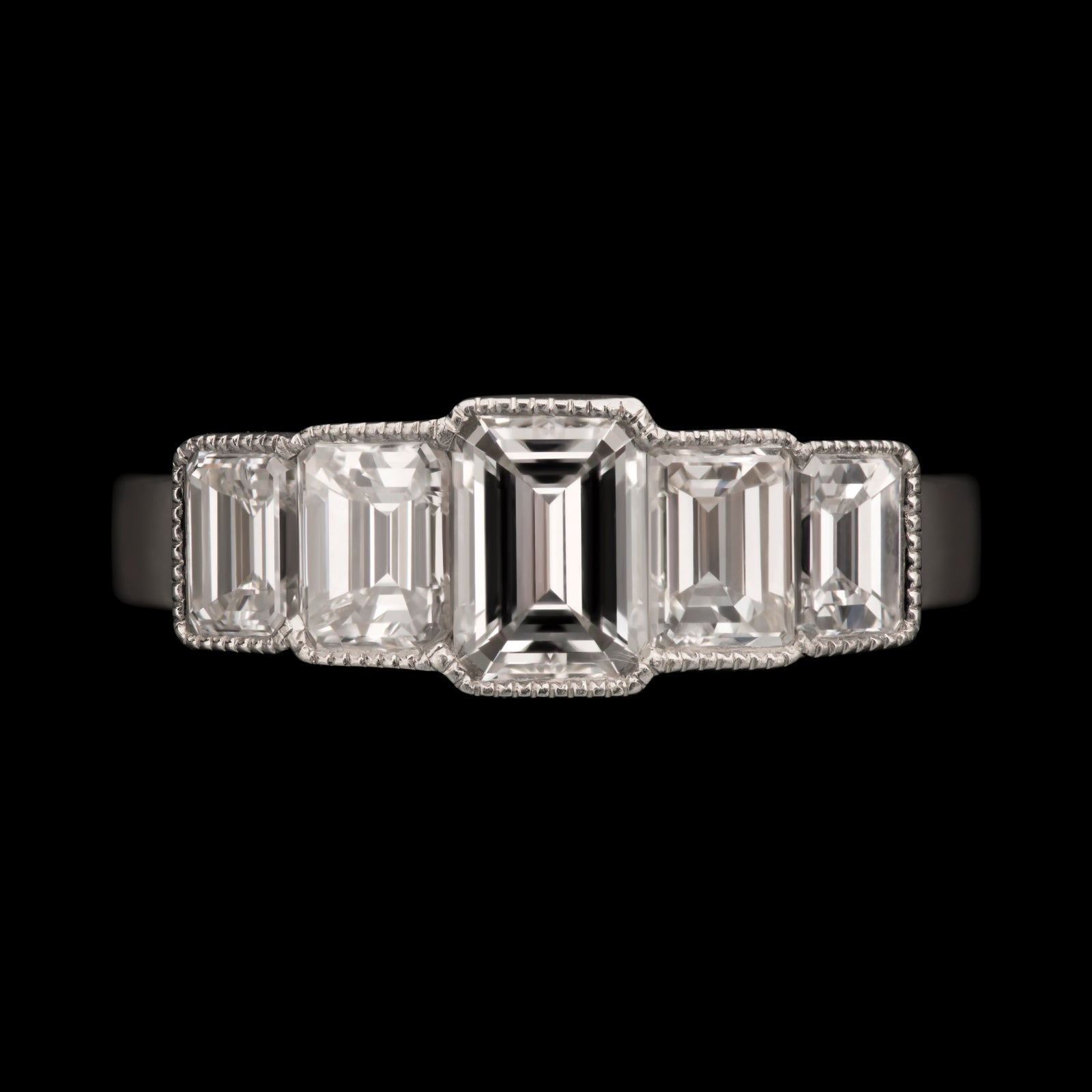 An Emerald Cut Diamond Five Stone Half Hoop Ring