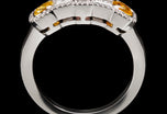 An all diamond half hoop ring with three fancy natural colour diamonds.